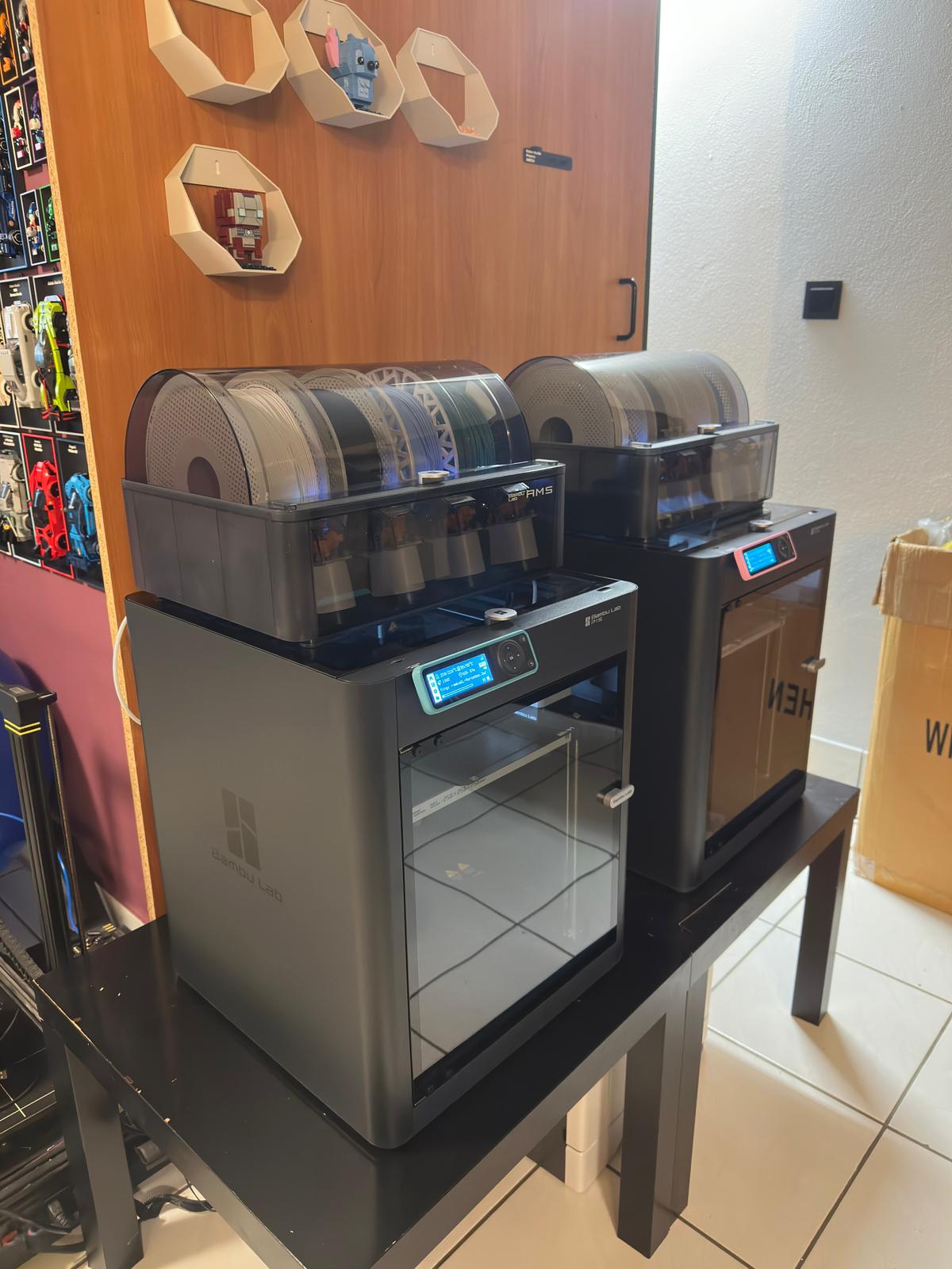Drukarki 3D Bambu Lab w warsztacie Hobby Crafts Creates, na ścianie widoczne gotowe modele